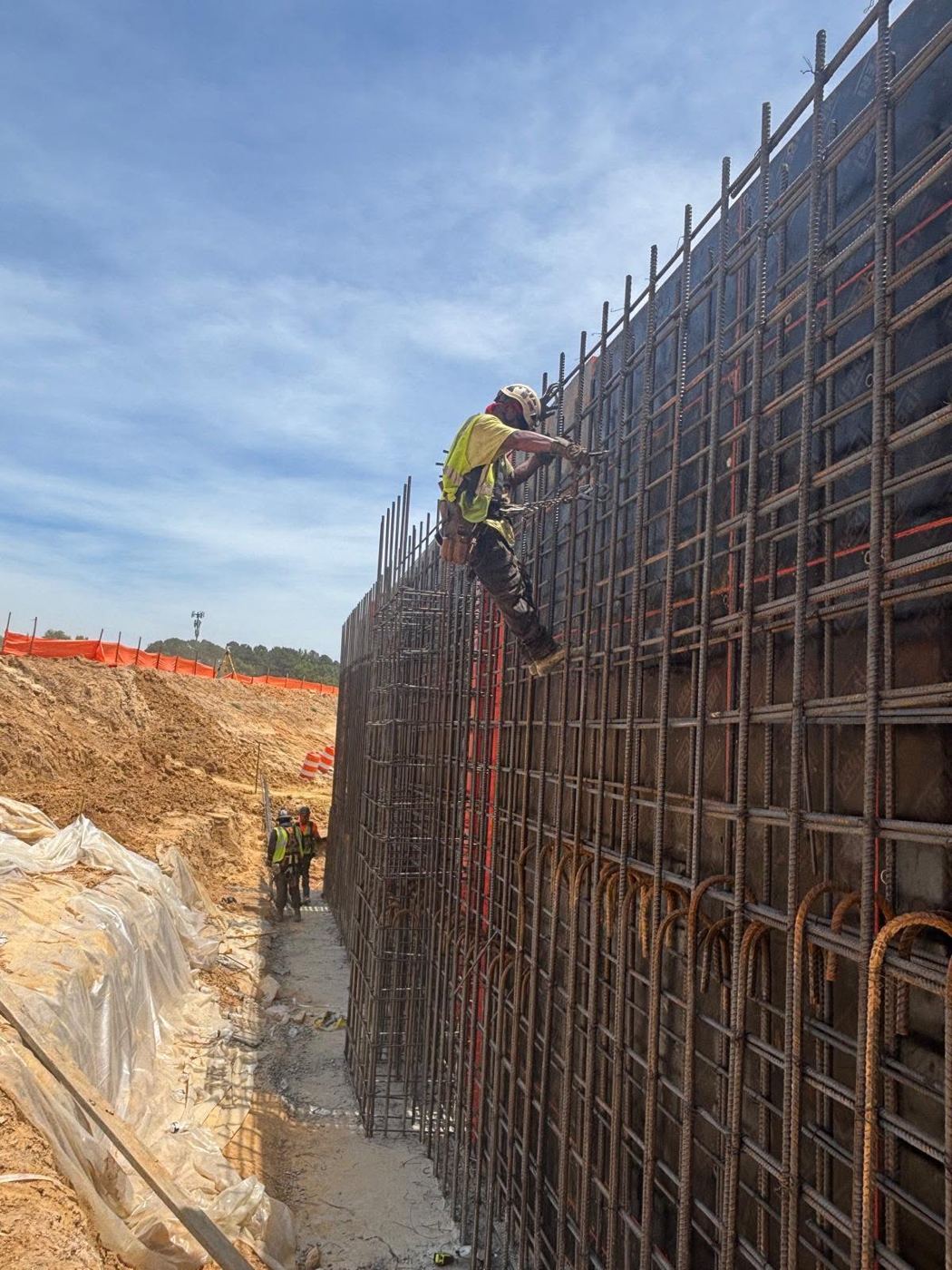 Ironworker tying a tall reinforced wall